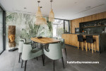 Open-plan dining room and kitchen featuring nature-inspired wallpaper